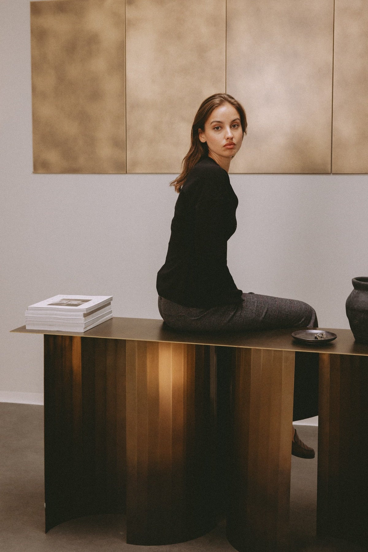 Model auf der TUKKON CONSOLE aus Messing vor Wandpaneelen aus Messing