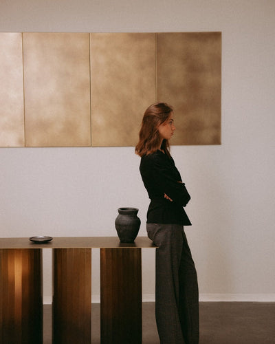 Lookbook : femme devant un mur en laiton avec la TUKKON CONSOLE