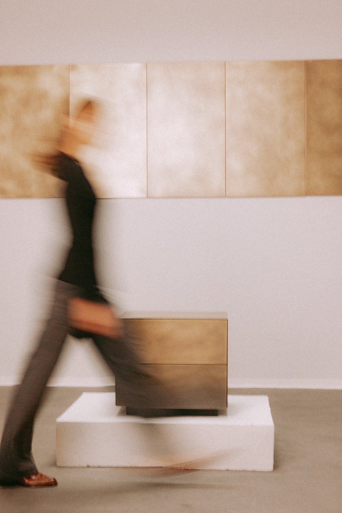 Model in Bewegung vor YORU aus Messing und Wandpaneelen